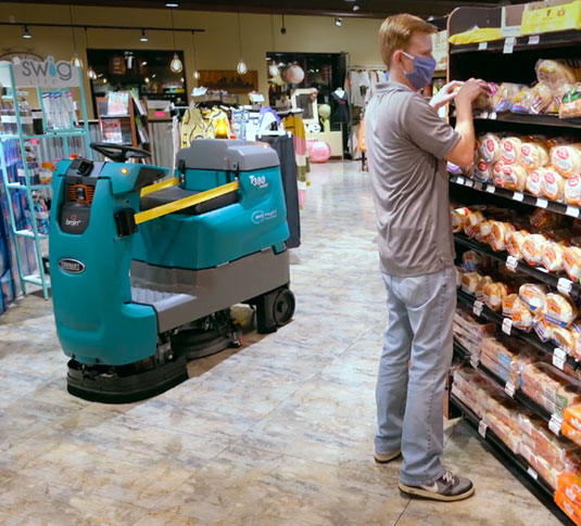 正在清洁杂货店过道的坦能机器人洗地机